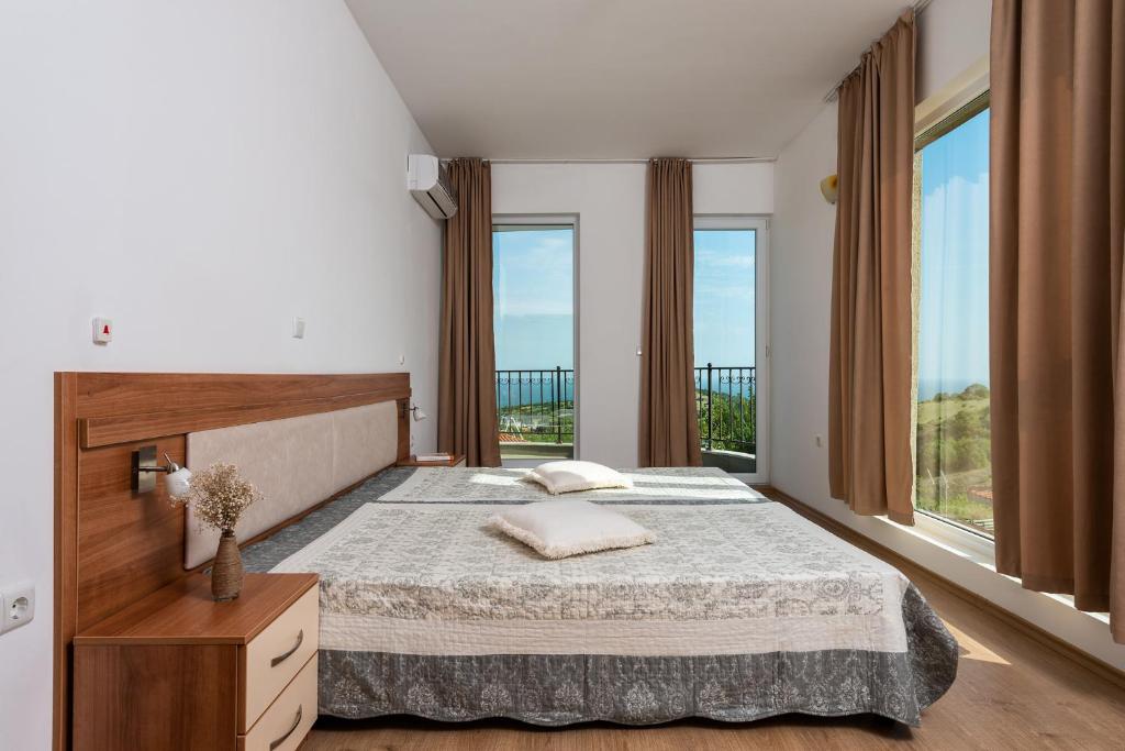 a bedroom with a large bed and large windows at Villa Entre in Emona