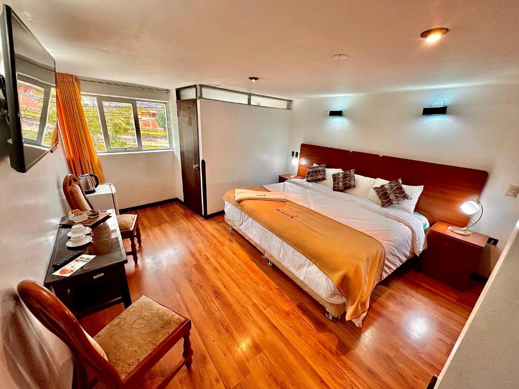 um quarto com uma cama grande e uma cadeira em Mama's House em Cusco