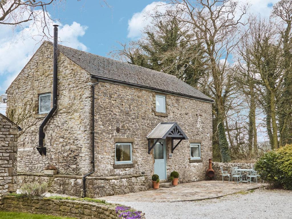 a stone cottage with a table and chairs in front of it at Bramble in Bakewell