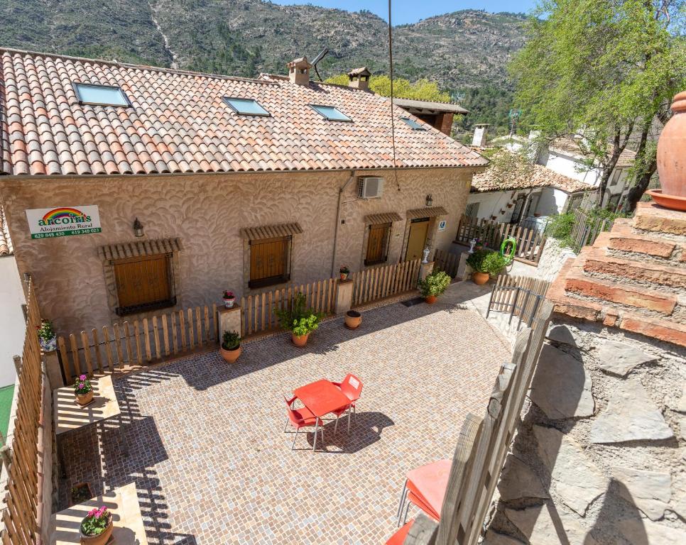 a house with a patio with a table and a fence at Alojamiento Rural Arco Iris in Arroyo Frio