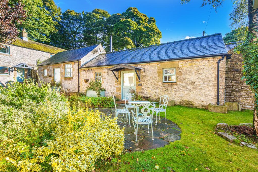 a cottage with a table and chairs in the yard at Slipper Lo in Bakewell