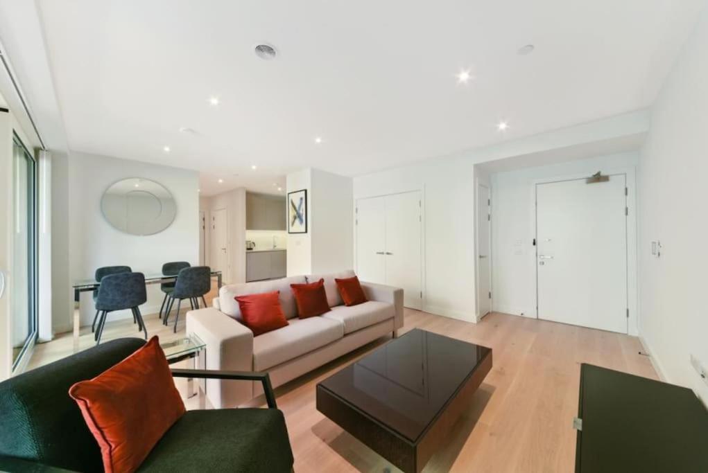 uma sala de estar com um sofá e uma mesa em Stunning Zone 1 Luxury Brand New 2 Bed Apartment em Londres