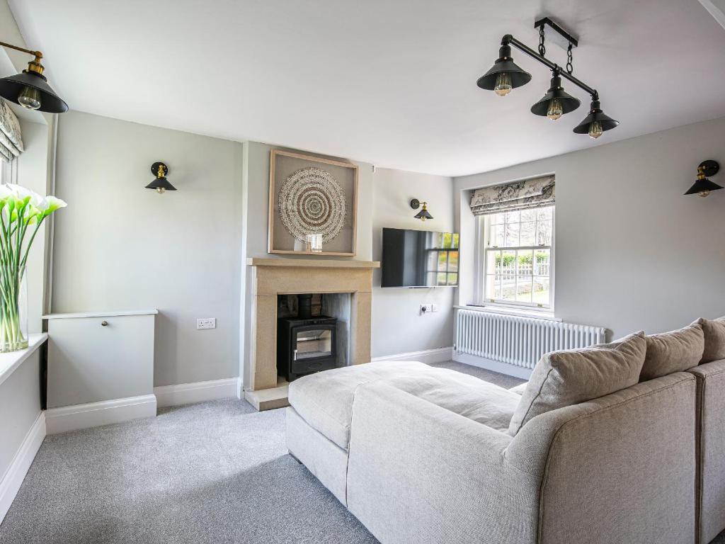 a living room with a couch and a fireplace at The Belle in Bakewell