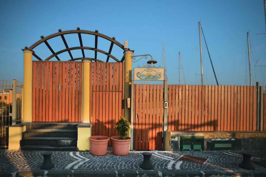 a red gate with plants in front of a building at La Capannina in Procida