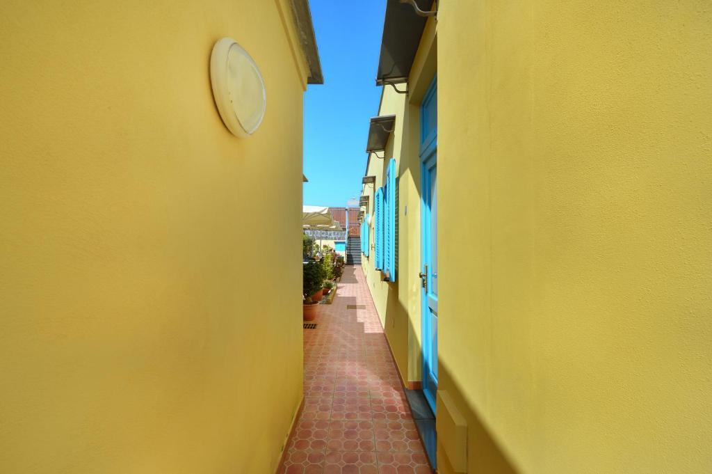 an alley between two buildings with a clock on the wall at La Capannina in Procida