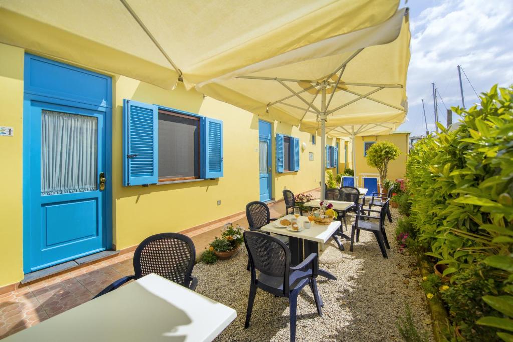 a patio with tables and chairs and an umbrella at La Capannina in Procida