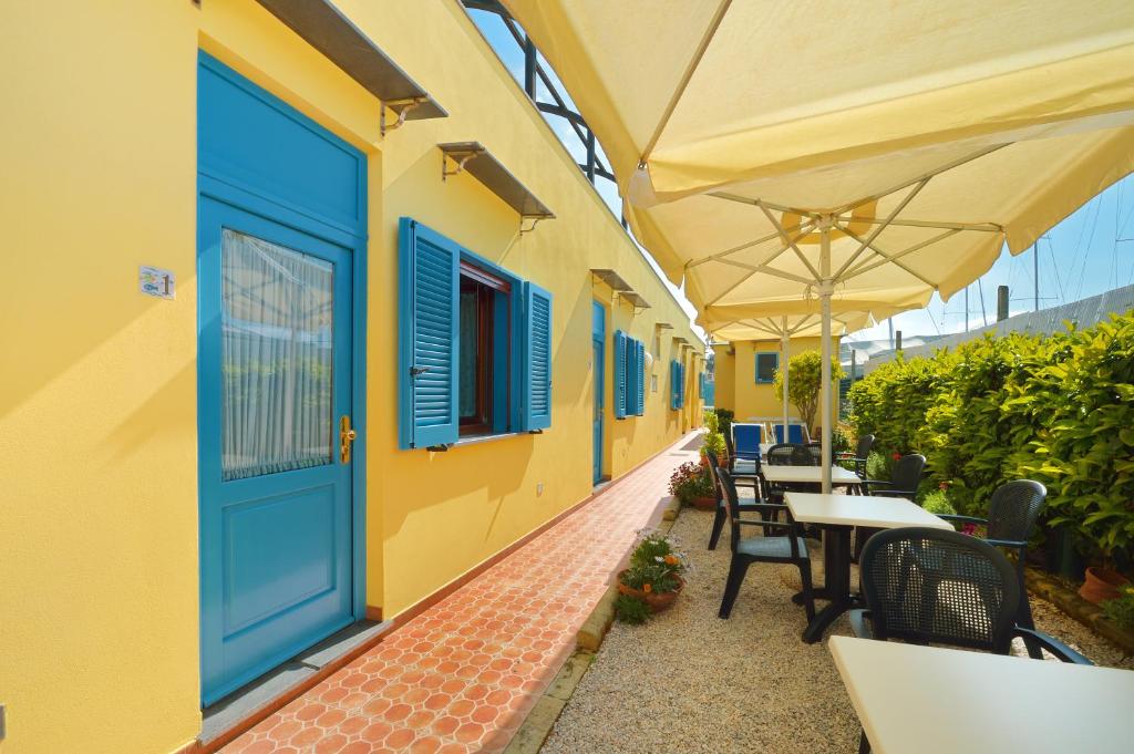 an outdoor patio with a blue door and tables and chairs at La Capannina in Procida