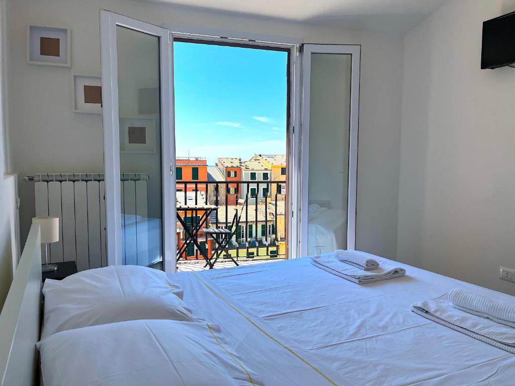 a bedroom with a bed and a view of a balcony at Pellegrino Rooms in Vernazza