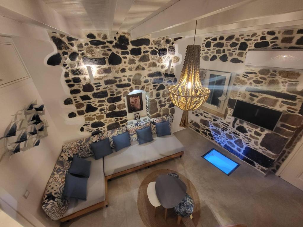 an overhead view of a living room with a stone wall at Spiliani View in Mandrakion