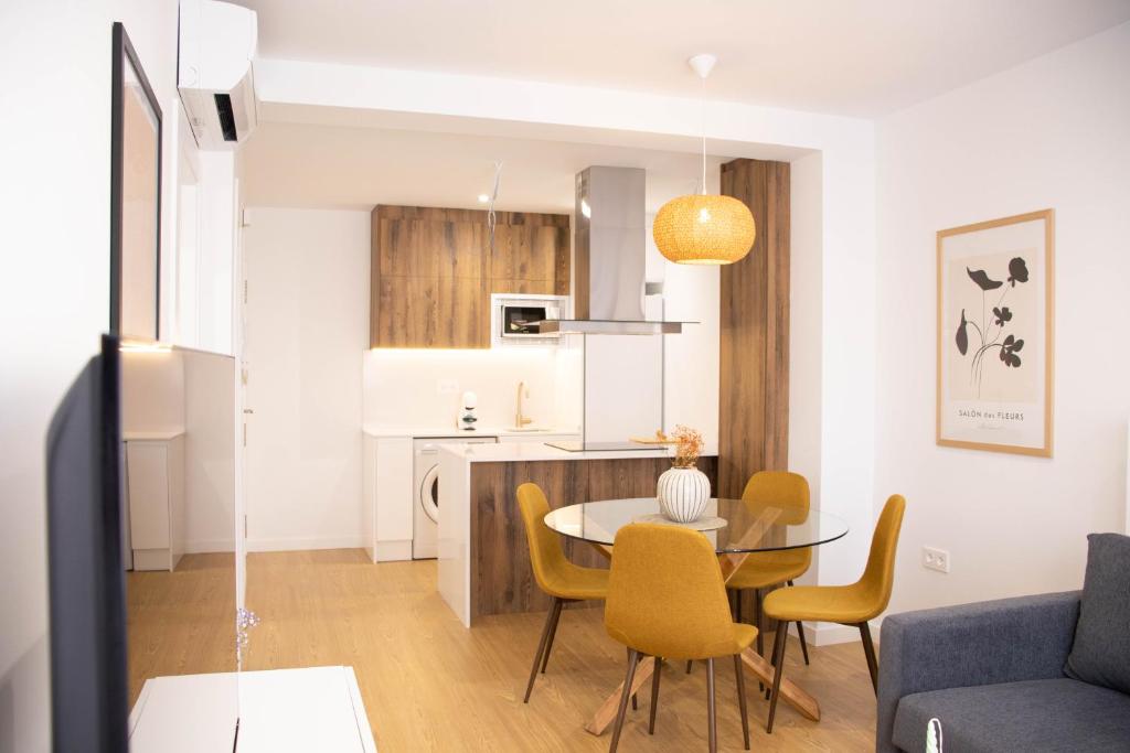 a living room and kitchen with a table and chairs at Apartamentos Fleming in Albacete