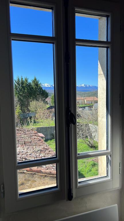 a window with a view of a stone wall at Maison Marie in Lagarde