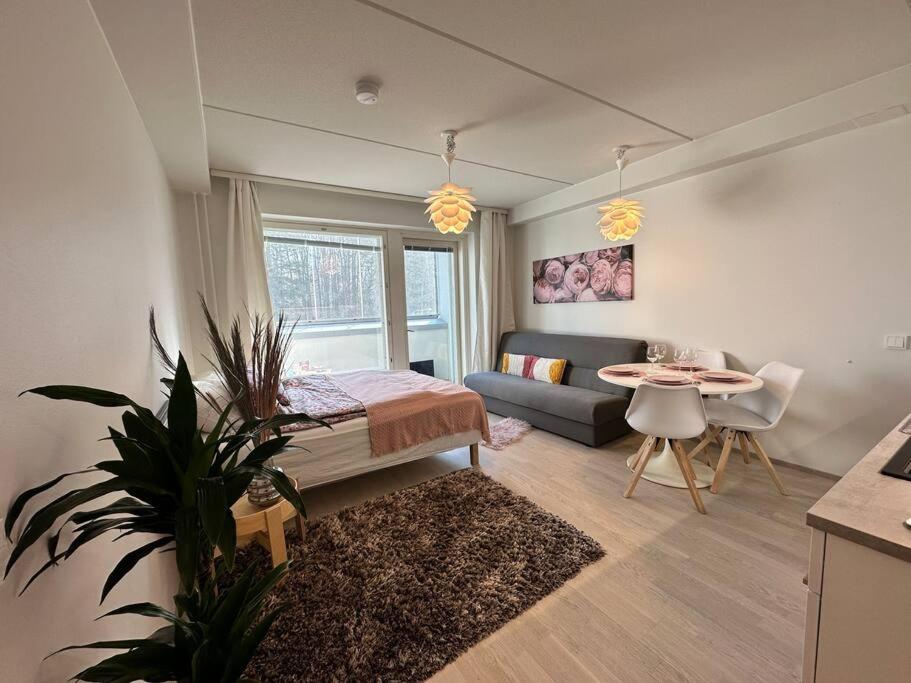 埃斯波Aurora Home Finnoo Espoo - studio next to metro, easy to reach Helsinki and Otaniemi, Aalto University and Iso Omena shopping center的带床和桌子的客厅
