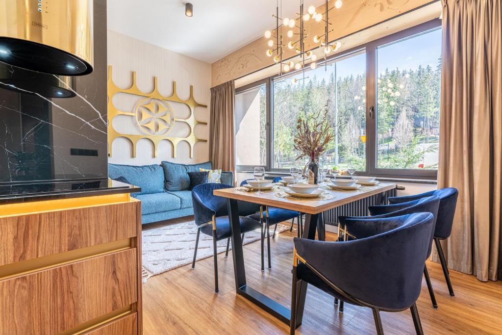 a dining room with a table and chairs and a couch at Piaseckiego Residence SPA in Zakopane
