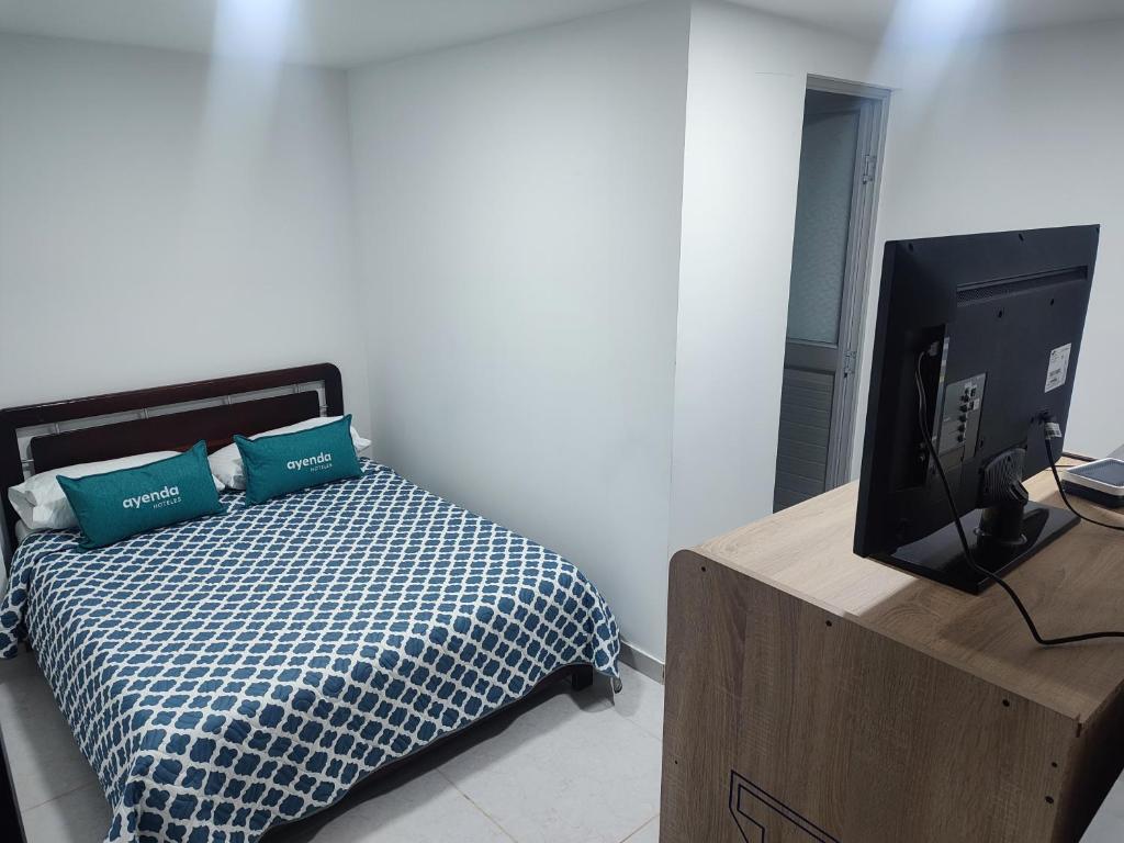 1 dormitorio con 1 cama y TV en una caja de madera en Hotel torre 15, en Bogotá
