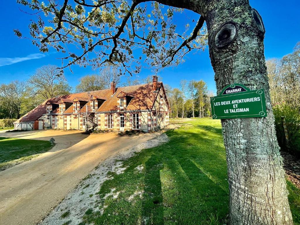 a sign on a tree in front of a house at Domaine de Charnay Villégiature Sologne in Vierzon