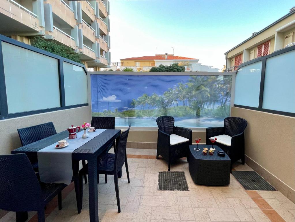 a balcony with tables and chairs and a large window at {Perla d'aMare ~ Zaffiro} Appartamento sul mare in San Benedetto del Tronto