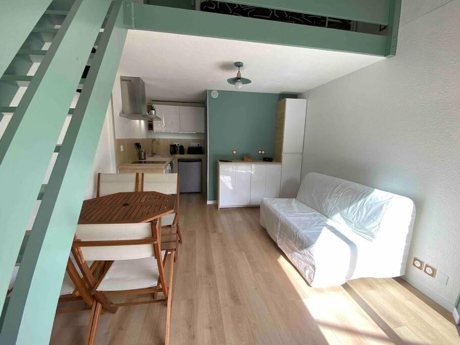 Zimmer mit einem Tisch und einem Bett sowie einer Küche in der Unterkunft Hourtin Port - Maison rénovée avec jardin à 150 m du lac in Hourtin