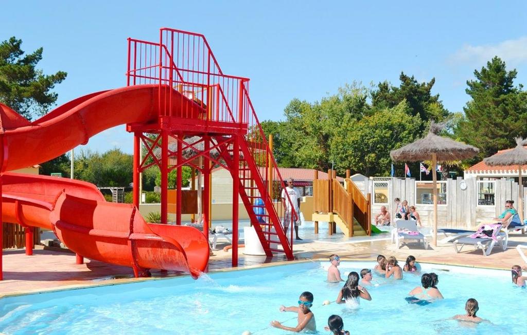 grupa osób w basenie ze zjeżdżalnią w obiekcie Camping Bretignolles-sur-Mer w mieście Brétignolles-sur-Mer