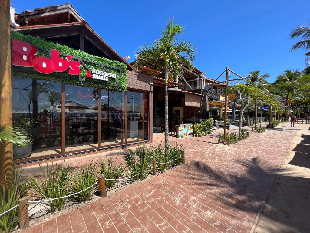 un restaurante en una calle con palmeras delante en casa Beira mar 2° praia, en Morro de São Paulo