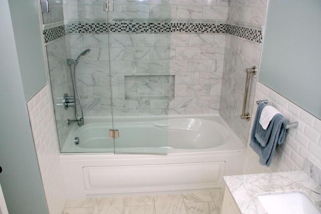 een badkamer met een bad en een glazen raam bij A Cool Pad Vacation Rental: 4 Bedroom 3.5 bath in Wallkill
