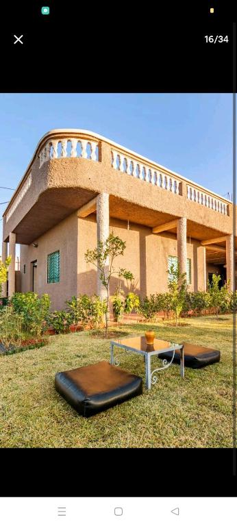 a large building with a table in the grass at La ferme d'Aghmat in Marrakech