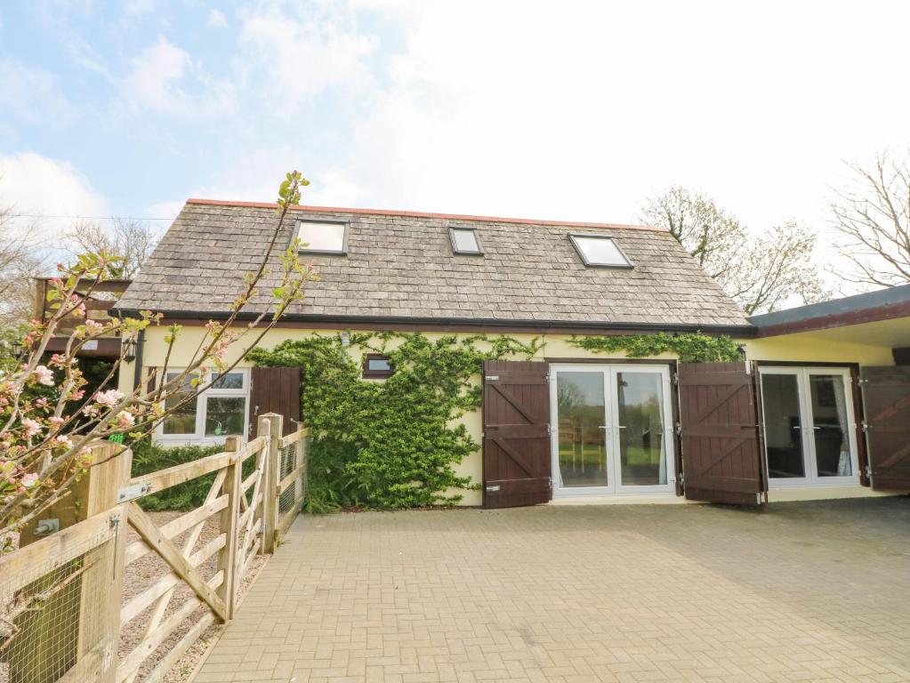 a house with a garage and a fence at Higher Kernick Stable in Bodmin