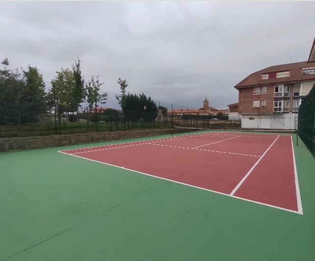 a tennis court with a red and green at Piso en Ajo con piscina comunitaria in Ajo