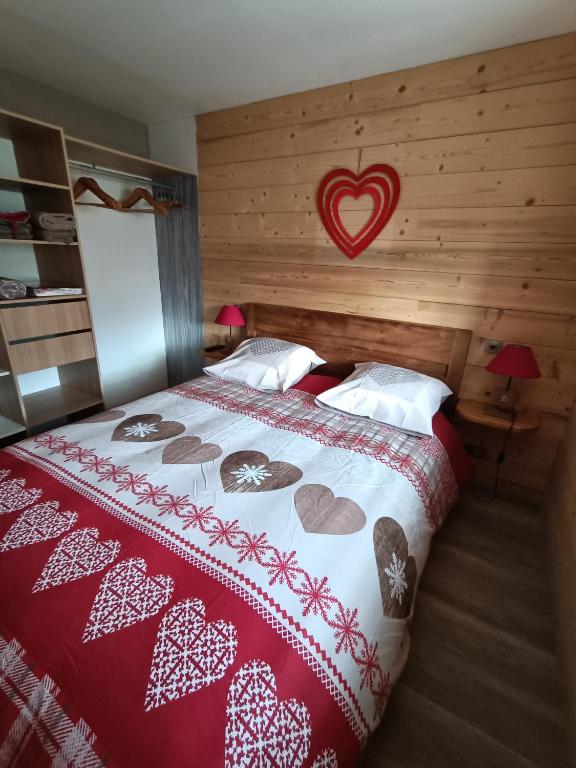 sypialnia z łóżkiem z czerwono-białym kocem w obiekcie Chez ma Grand-mère w mieście Saint-Félix