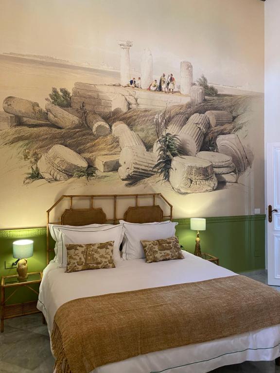um quarto com uma cama grande e uma pintura na parede em Dar Alice em Soûr
