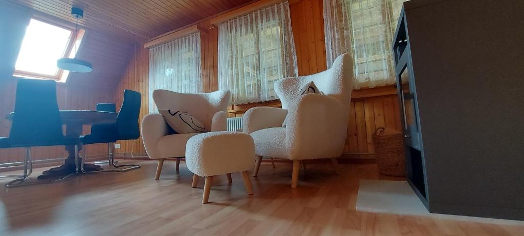 um quarto com cadeiras, uma mesa e uma televisão em 2 Zimmer-Wohnung zur Erholung im Emmental 