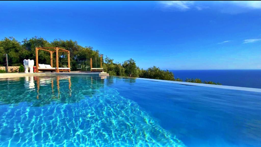 a swimming pool with a view of the ocean at PARGA Villas Collection in Parga
