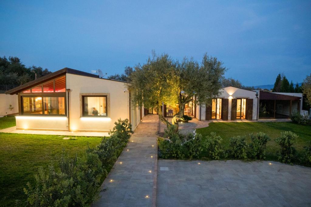 a house with a pathway leading to it at night at La Manica Rooms in Milazzo