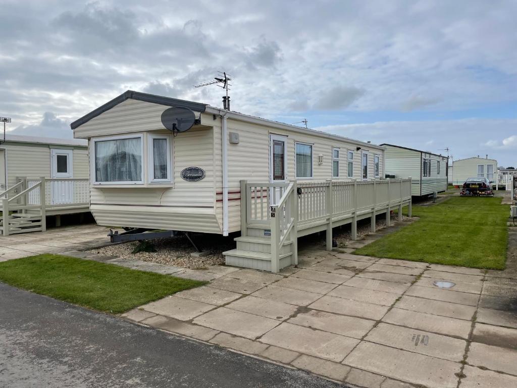 a row of mobile homes parked in a parking lot at Golden Palm Resort TM5 in Chapel Saint Leonards