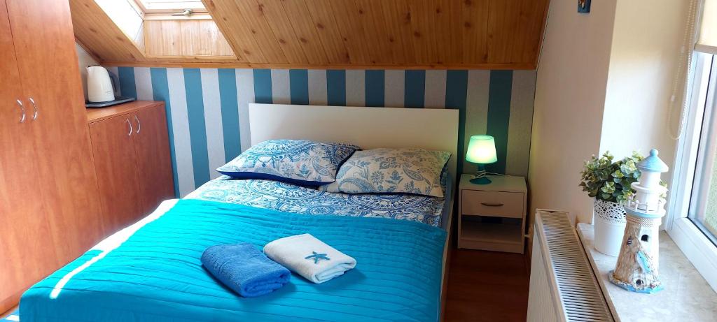 a bedroom with a bed with blue sheets and pillows at Willa Folta in Władysławowo