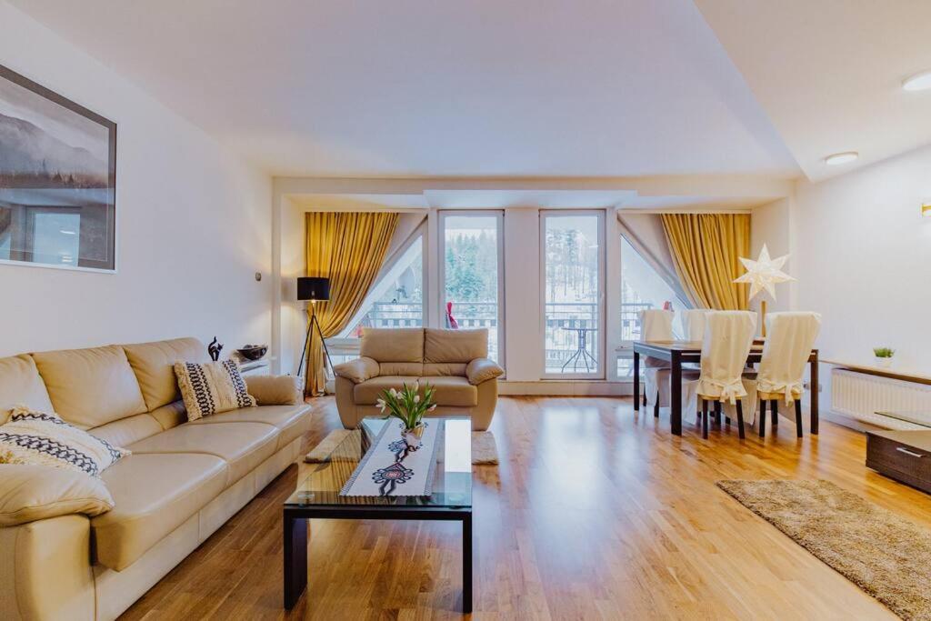 a living room with a couch and a table at Apartament Bukowa Mountain Wisla in Wisła