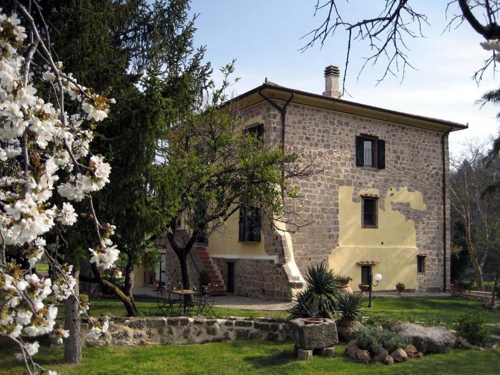 an exterior view of a stone house with trees at San Processo Agriturismo in Castel del Piano