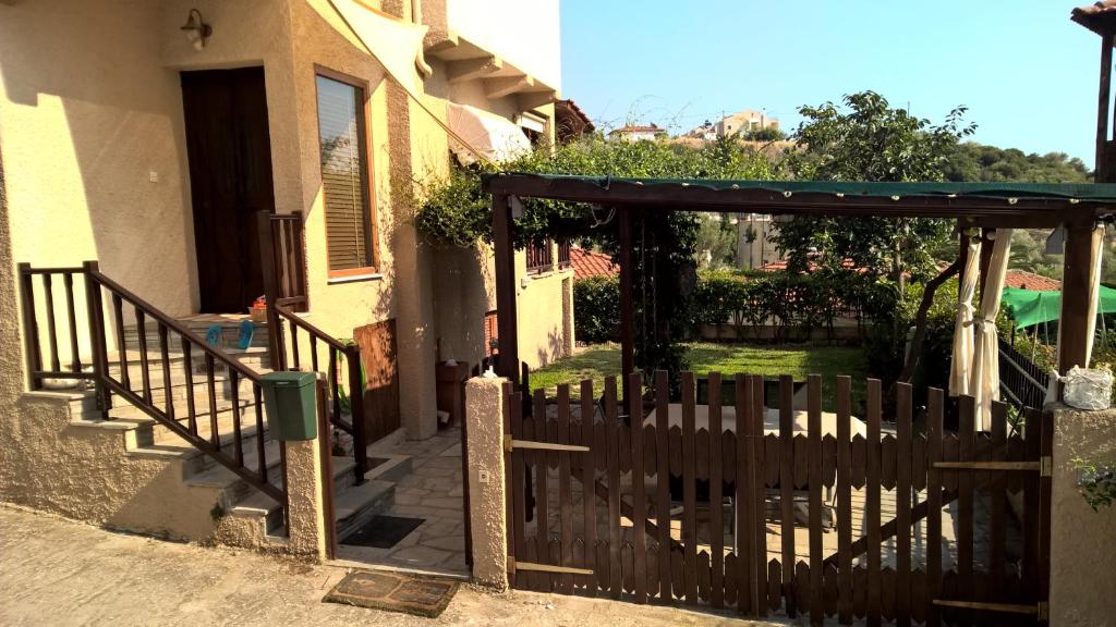 a wooden gate to a house with a porch at Euphoria beach house in Paleo Tsifliki