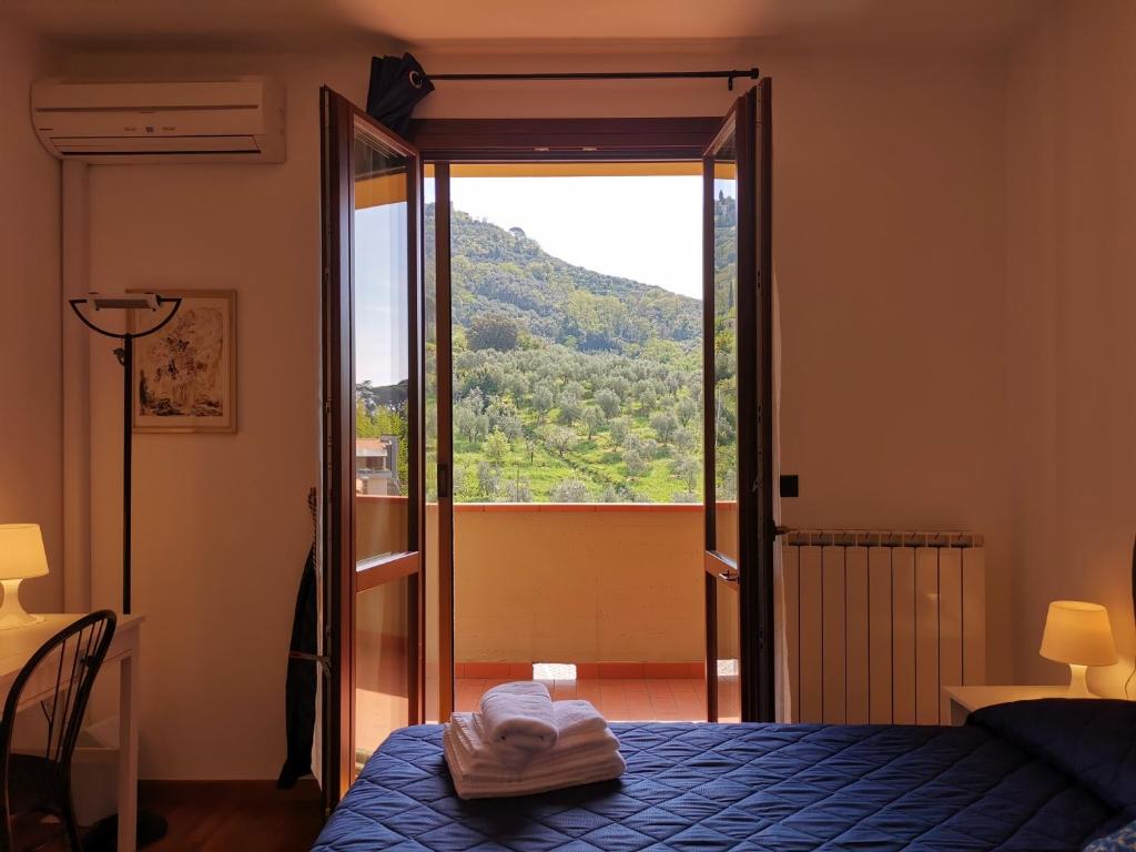 een slaapkamer met een bed en een deur naar een balkon bij 7 Panorama in Montecatini Terme