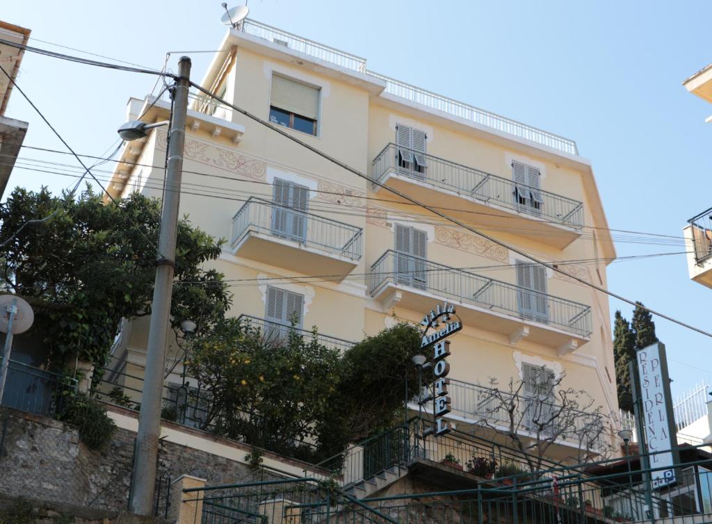 żółty budynek z balkonami na ulicy w obiekcie Hotel Villa Amelia w Alassio