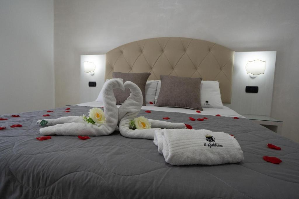 una camera da letto con un letto con asciugamani e fiori di B&B Il Gabbiano a Porto Cesareo