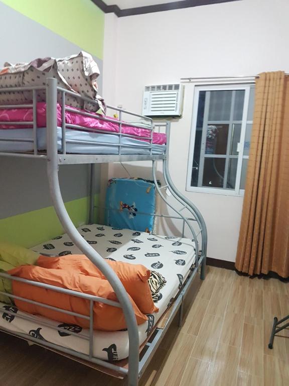 Ce lit superposé se trouve dans un dortoir doté d'une fenêtre. dans l'établissement JZA Transient House, à Cagayán de Oro