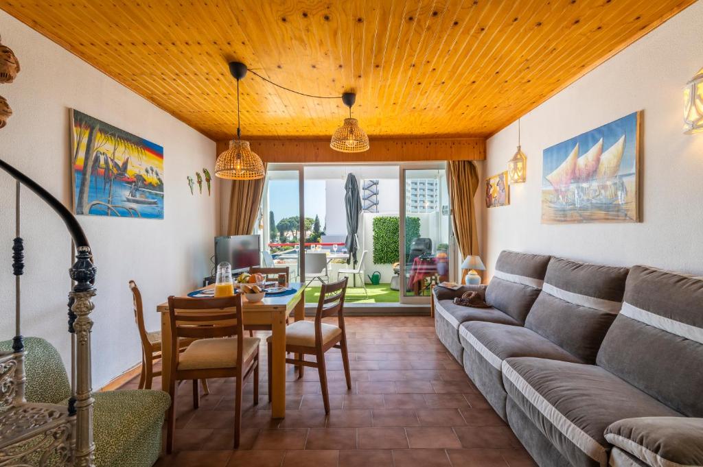 een woonkamer met een bank en een tafel bij Casa do Sol Residence in Albufeira