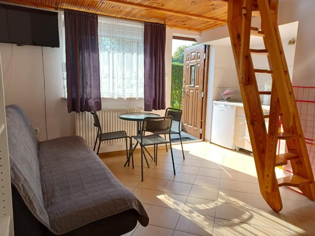 Pokój z łóżkiem i stołem oraz kuchnią w obiekcie Słoneczne Apartamenty w mieście Mielno
