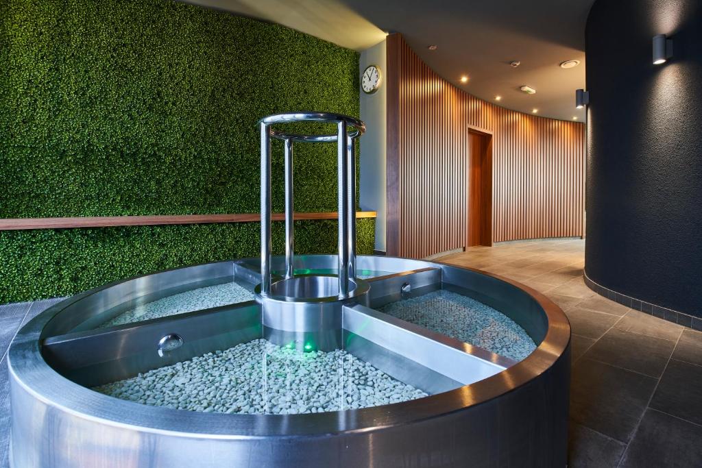 a hot tub in a room with a green wall at Spa Hotel Felicitas in Poděbrady