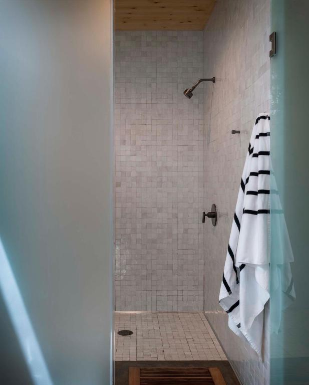 a bathroom with a shower with a black and white towel at AutoCamp Yosemite in Midpines