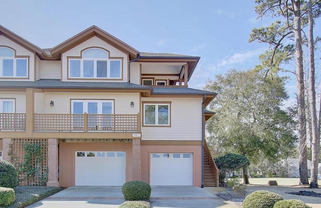 a house with two garage doors and trees at Fairway to Heaven home in Supply