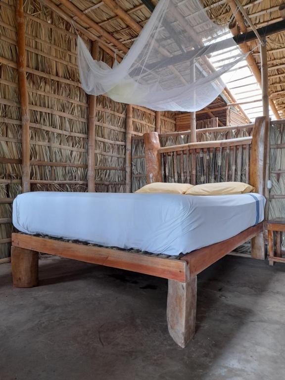 Cama en habitación con red en El Bamboo Cabins en Balgue