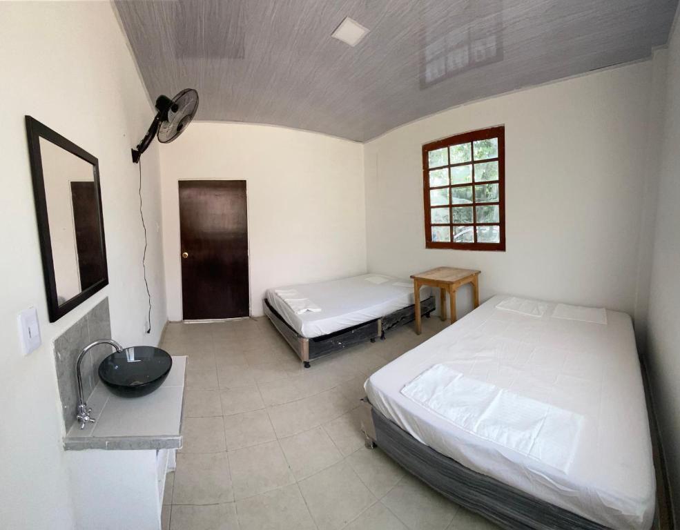 a bedroom with two beds and a table and a window at La Casa de Luna in Carmen de Apicalá