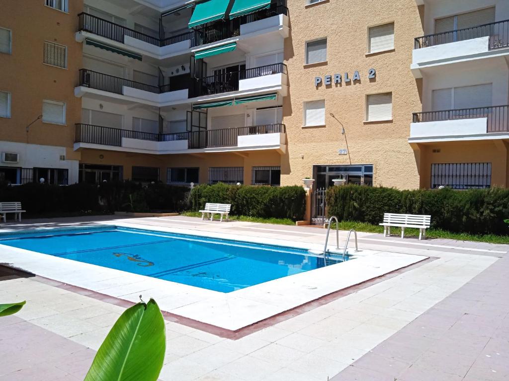 une piscine en face d'un bâtiment dans l'établissement FUENGIROLA ESTUDIO PLAYA PERLA 2, à Fuengirola