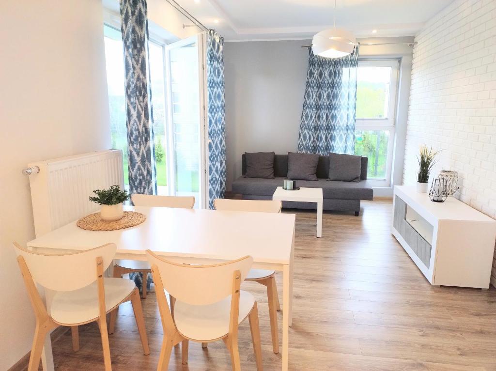 a living room with a table and chairs and a couch at Garden Apartment in Wieliczka